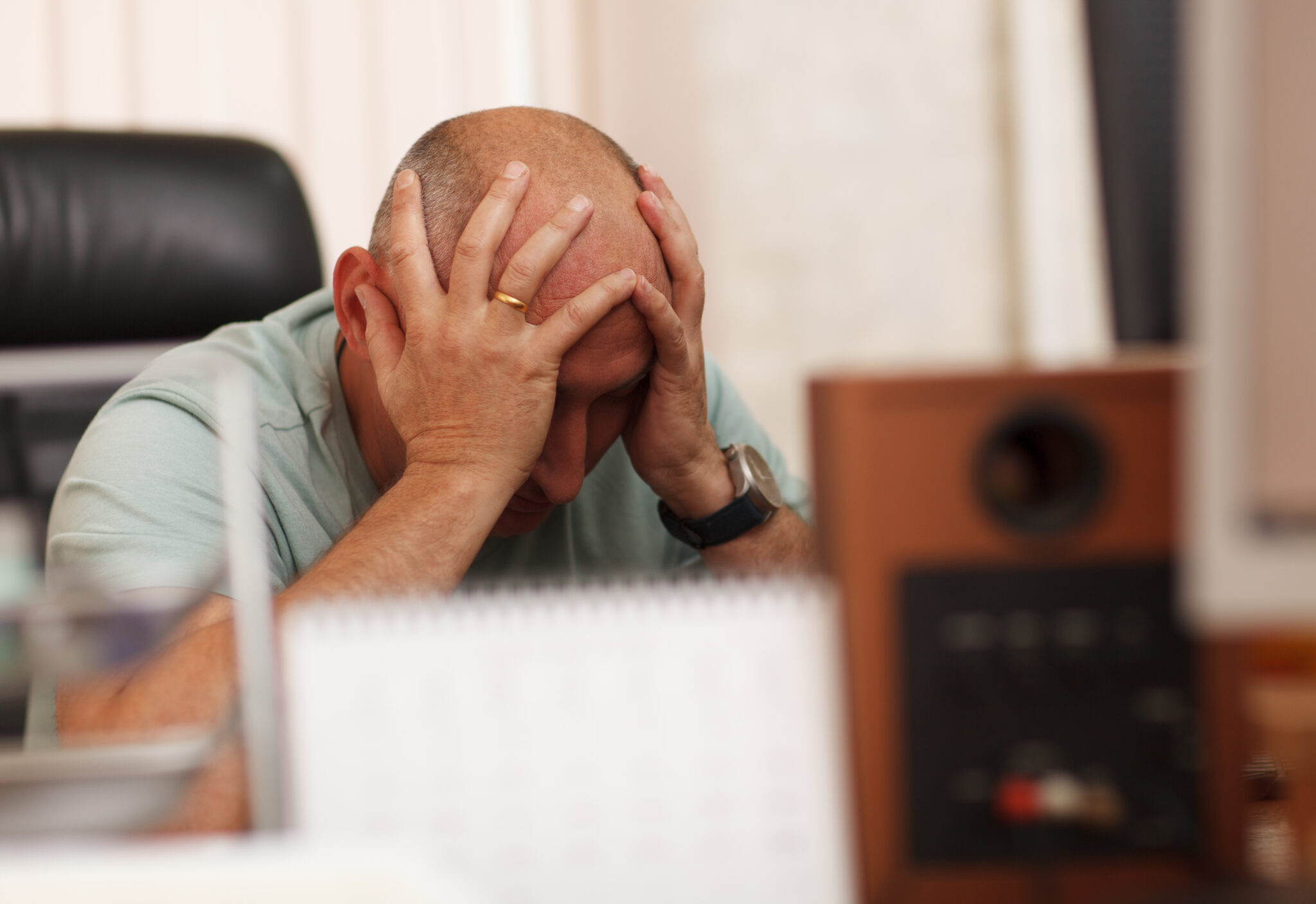 Frustrated business man with his head in his hands because he's got a poor performer